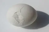A cracked egg on a white background