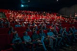 A cinema room filled with people looking towards the screen.