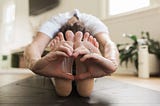 Heart hands on feet while stretching yoga