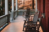 Front porch with empty rocking chairs.