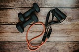 Two lightweight dumbbells and an elastic workout band with handles