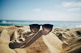 A pair of Ray-Bans sitting in the sand