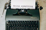 Vintage typewriter that says “write something”