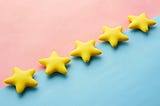 Five yellow stars on a diagonal line split between pink and blue. A list of my top five most-read Medium stories.