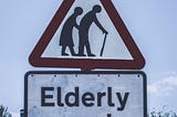 Picture of an elderly couple on a road sign via Alt text on Medium