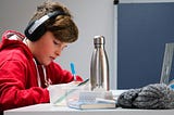 boy with earphones, appearing to study