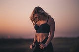 fit women standing in front of a sunset