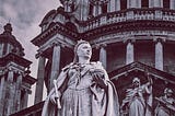 Monochrome image showing a marble statue of Queen Victoria outside Belfast City Hall