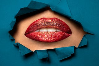 closeup of a woman’s mouth with red lipstick and glitter