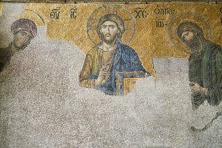In image of Jesus in the Greek Coptic sytle with a halo circle behind his head. along wtih two other teachers or discilples. its an unfinished fresco. so bottom half of the image is undecorated.