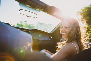 Young woman is laughing sitting in car