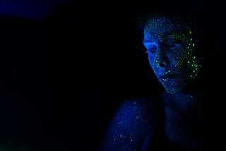 Photograph of a woman during nighttime, covered in glitter.