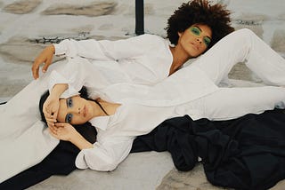 two women reclining in white outfits
