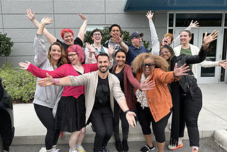 An image of 12 of the original participants in the Content Design Manifesto, with big smiles and arms-raised poses.