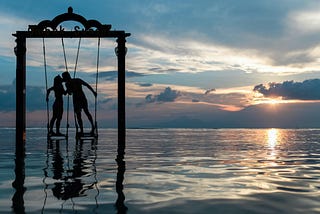 two lovers on a swing on a lake