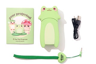 A stun gun shaped like a frog with a charger, strap, and guide book.