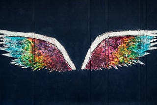 Colorful wings art on black background.