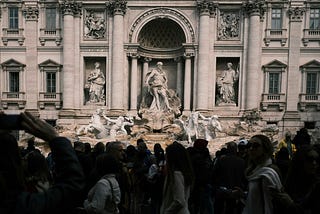 Trevi fountain in Rome, obscured by crowds.