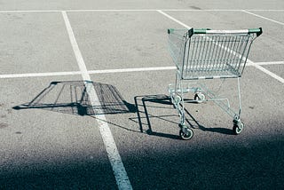 A lone shopping cart in an empty parking lot. Was it abandoned by someone who does not align with the The Shopping Cart Theory?