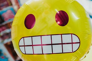a grimacing emoji, which is a nervous yellow face gritting their teeth