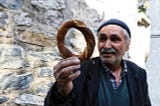 An old man gazes adoringly at a pretzel