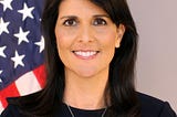 Official photo of U.S. Ambassador to the U.N. Nikki Haley standing in front of an American flag.