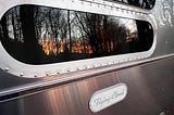 reflection of sunrise in my airstream flying cloud window