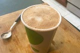 Closeup of a latte in a paper “to go” cup.