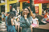 Asian woman on crowded sidewalk.