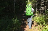 Man with a big pack sack hiking in the woods