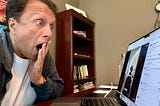 Author appearing surprised while looking at his laptop screen