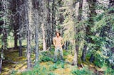Gentry Bronson standing in the woods shirtless and wearing dirty jeans in Alaska, 1991