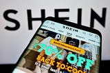 IMAGE: A cellphone with online shop of Chinese e-commerce company Shein on screen in front of business logo