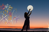 A woman holds the moon at sunset with fireworks and a setting sun also in the sky.