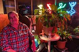 friendly lesbian bar staff sits at the entrance of Babe’s of Carytown in virginia with a pot plant next to her