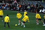 Barcelona players in yellow training tops warming up in a rondo