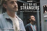 A movie poster with the words: All of Us Strangers and featuring two white men, one in his mid 20s the other in his 40s, standing apart from one another in an elevator.