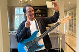 Author posing for a selfie while holding a guitar