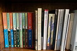 Books by P G Wodehouse on a bookshelf next to books by Virginia Woolf.