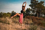 Calm dancer standing in field. Can you hack your menstrual cycle to boost your health & fitness goals?