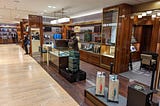 Upscale department store with gloved salesperson selling leather suitcases. If you have to ask the price, you can’t afford it, dear