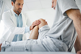 doctor evaluating a man’s knee
