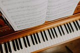 Sheet music set above a piano keyboard
