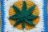 A cannabis leaf crocheted into a square.