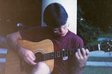 Old photo of a teenage boy playing guitar