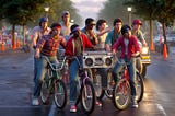 Group of kids from the 1980s riding bikes with a boombox