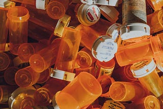 A pile of empty orange pill bottles