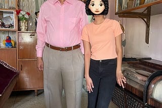 A senior citizen with his granddaughter. She is about sixteen. Both are dressed in pants and a shirt. Grandpa’s shirt has a collar and is full-sleeved, and the granddaughter is in a t-shirt.