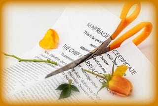 orange-handled scissors cutting up a marriage certificate and an orange rose