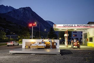 A double bed on a platform by a gas station